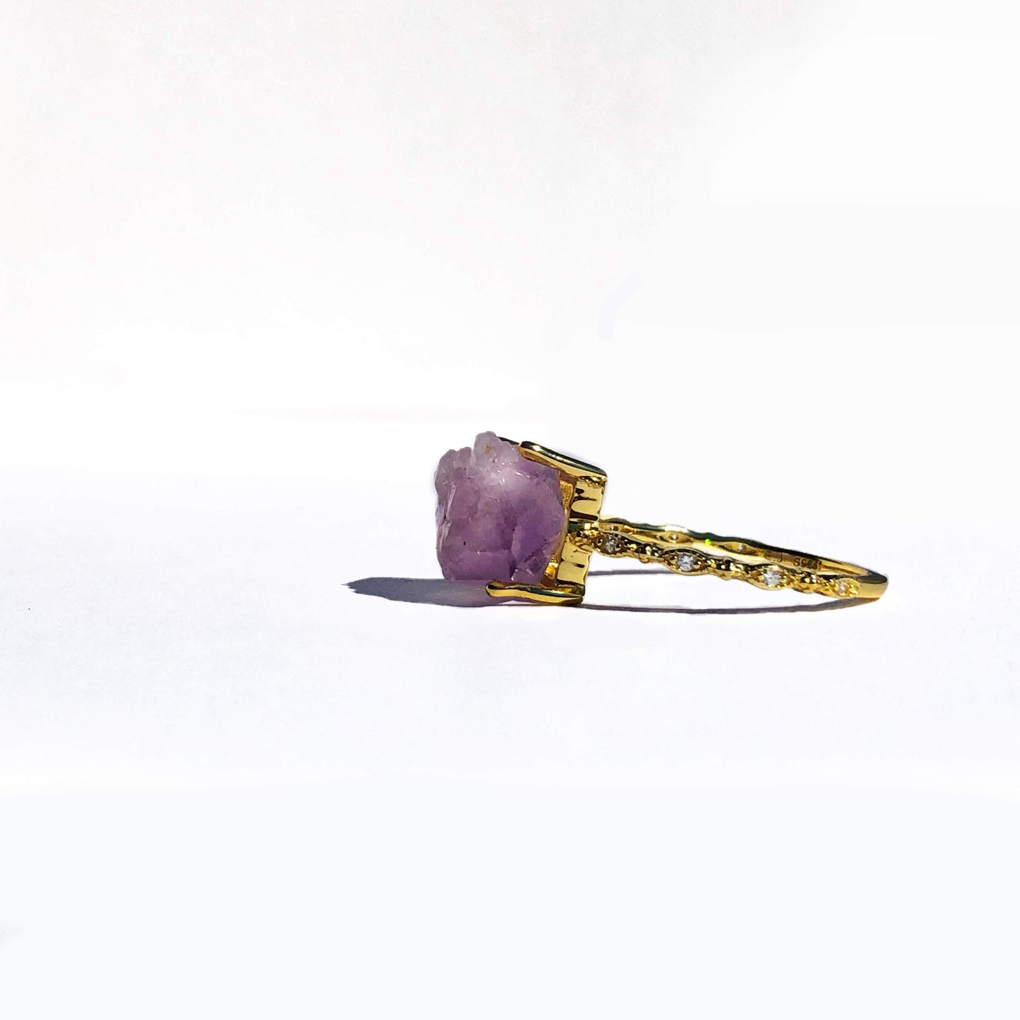 An incredibly rare mineral that only forms in high-temperature volcanic rock, amethyst is a powerful crystal thought to bring protection and to help you remember your dreams. This ring features a raw amethyst quartz stone,  dipped in 14K gold and trimmed with AAA-grade cubic zirconia stones to give it a glamorous feel. The band is made from .925 sterling silver to make it hypoallergenic for what will be your most worn ring.
